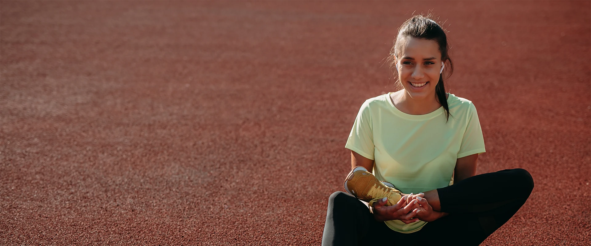 smiling-woman-relaxing-after-exercise-on-red-surface 800